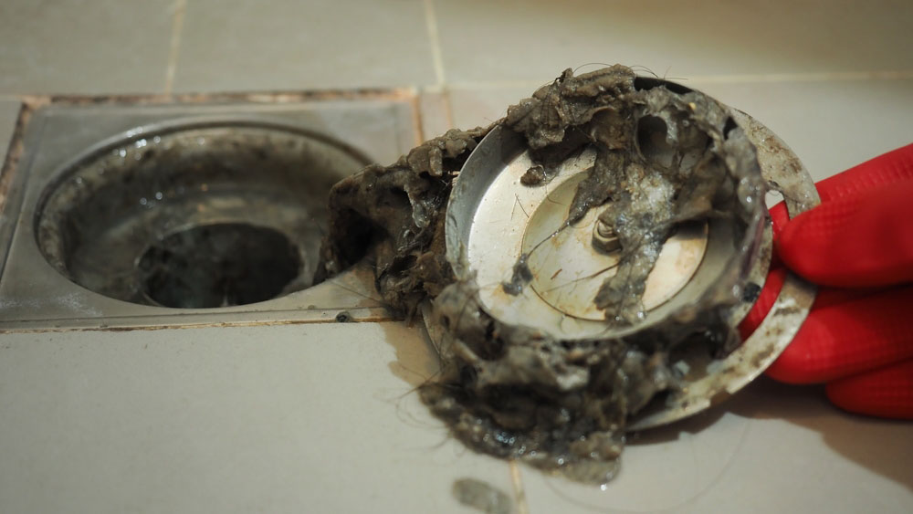Sugar Bear technician cleaning a residential drain